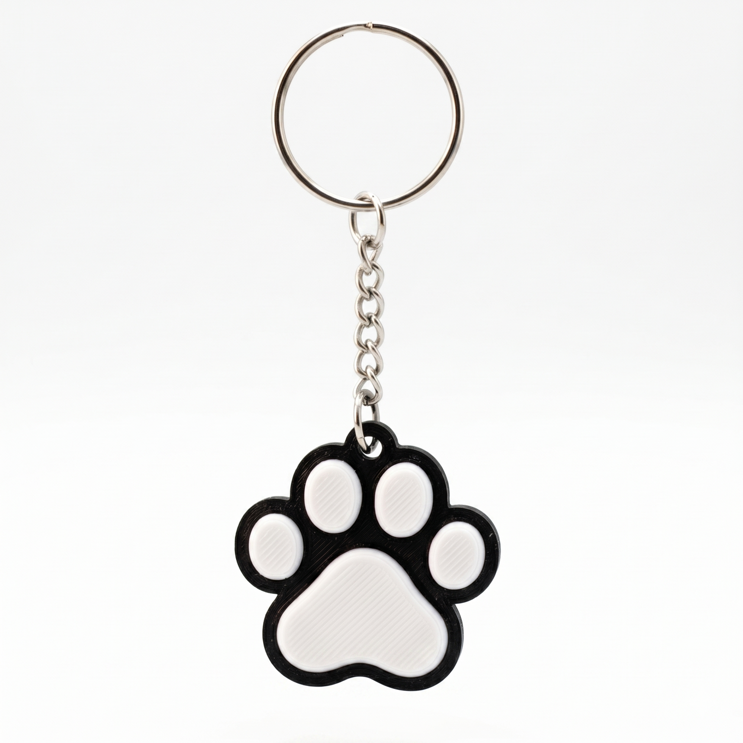 Keychain with a black and white paw print design on a white background