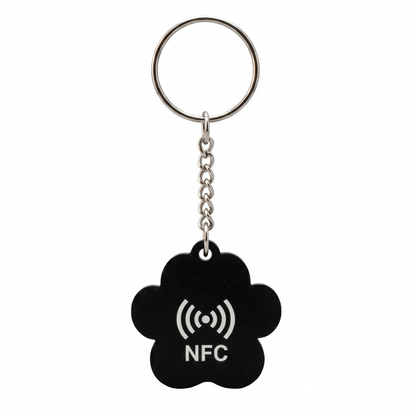 Black NFC keychain with a white symbol on a white background